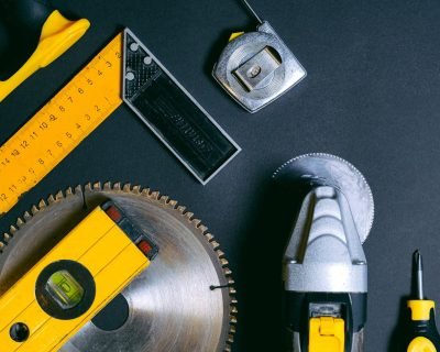 A selection of construction hand tools arranged flat lay style on a dark surface. Ideal for industry themes.