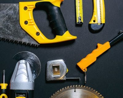 A collection of yellow and black construction tools arranged on a dark flat surface, ideal for DIY projects.